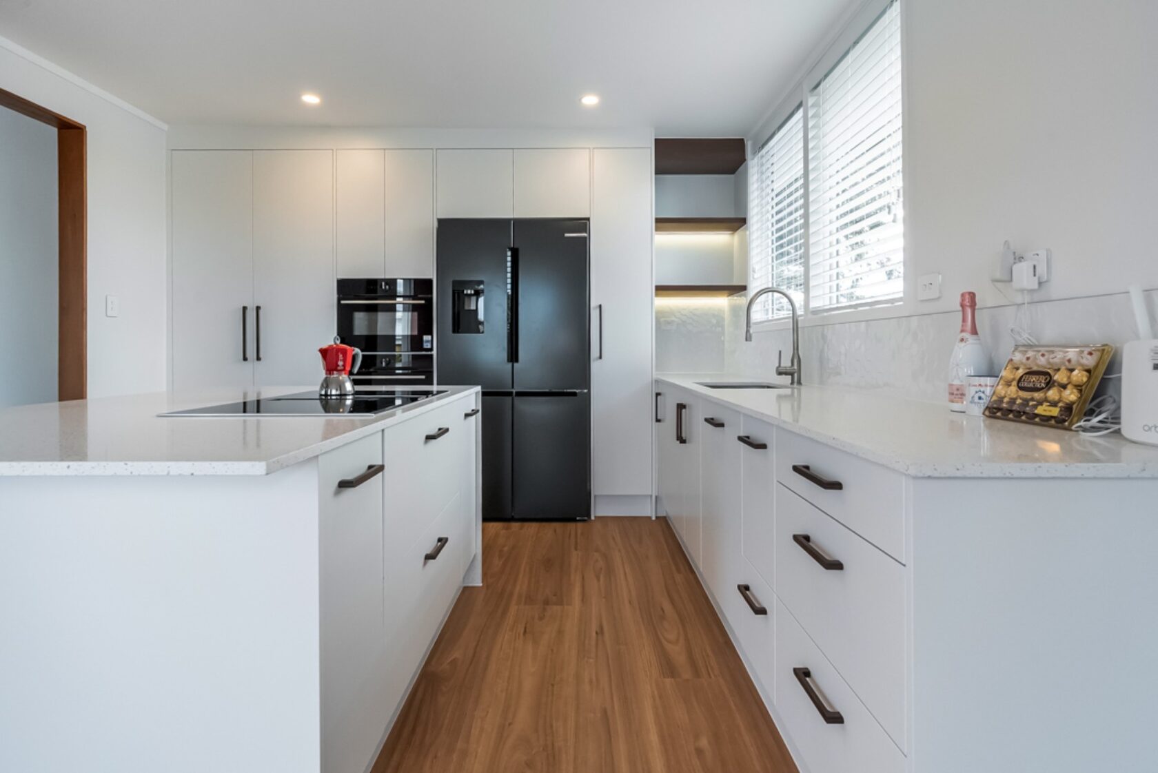 After: Hillcrest kitchen with a central island, white cabinetry and black refrigerator