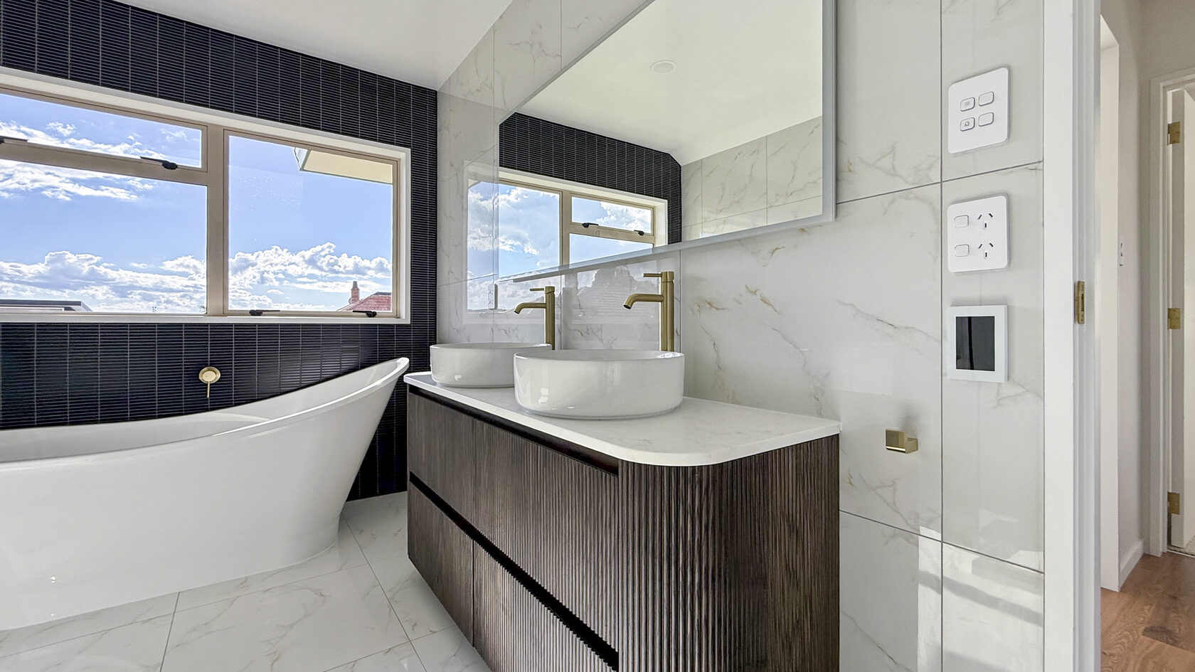 St Heliers bathroom with freestanding bath, double vessel basins and floating timber vanity.