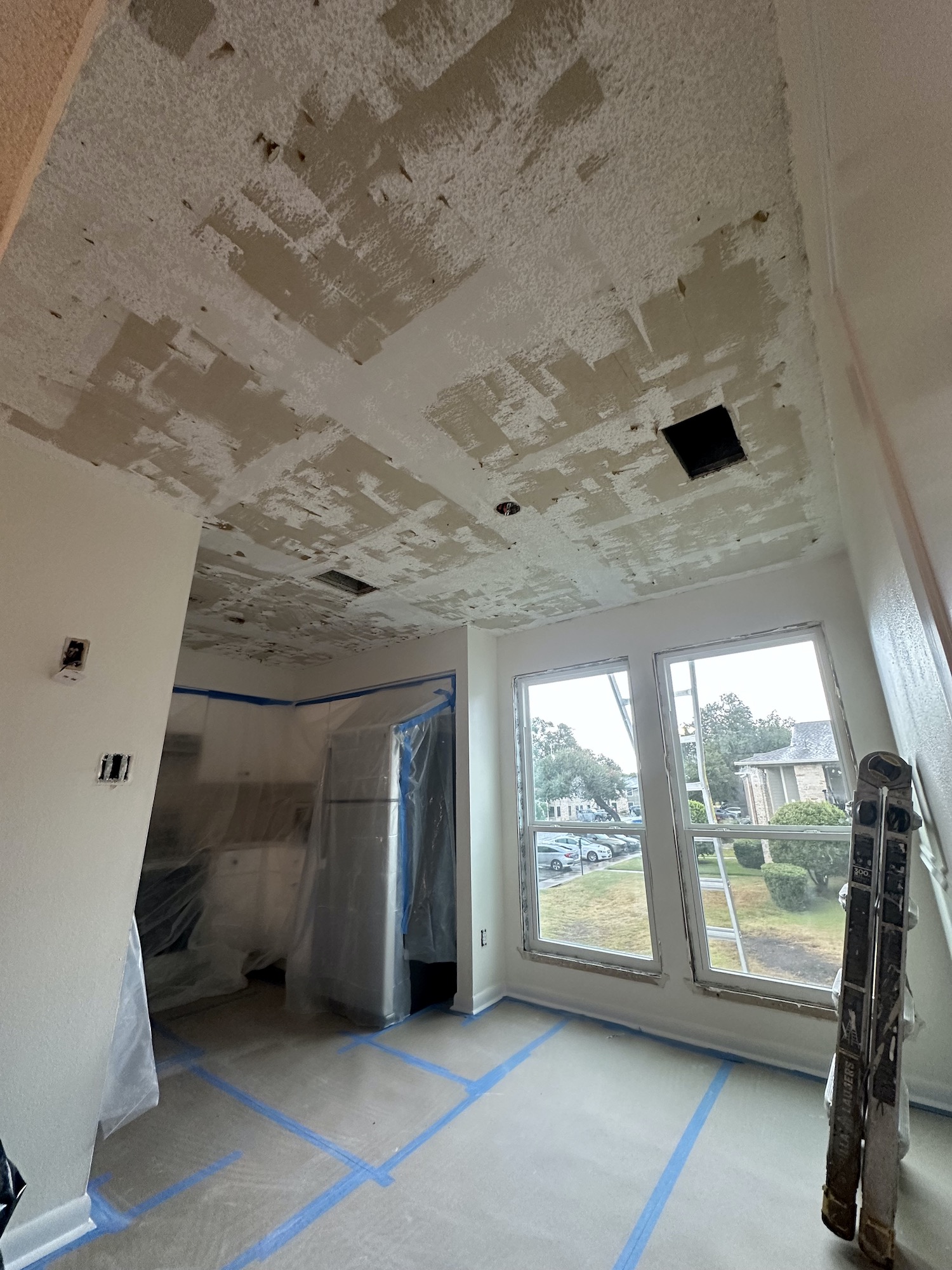 Living area protected during popcorn ceiling removal and skim coating