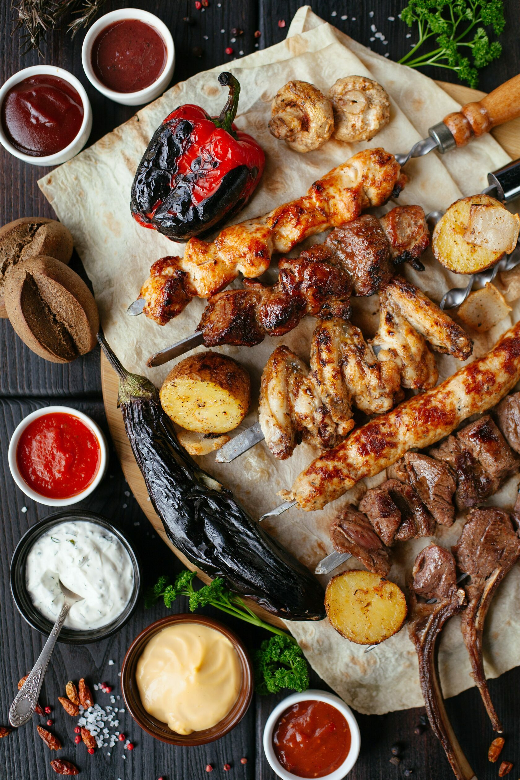 a variety of meats, vegetables and sauces on a skewer