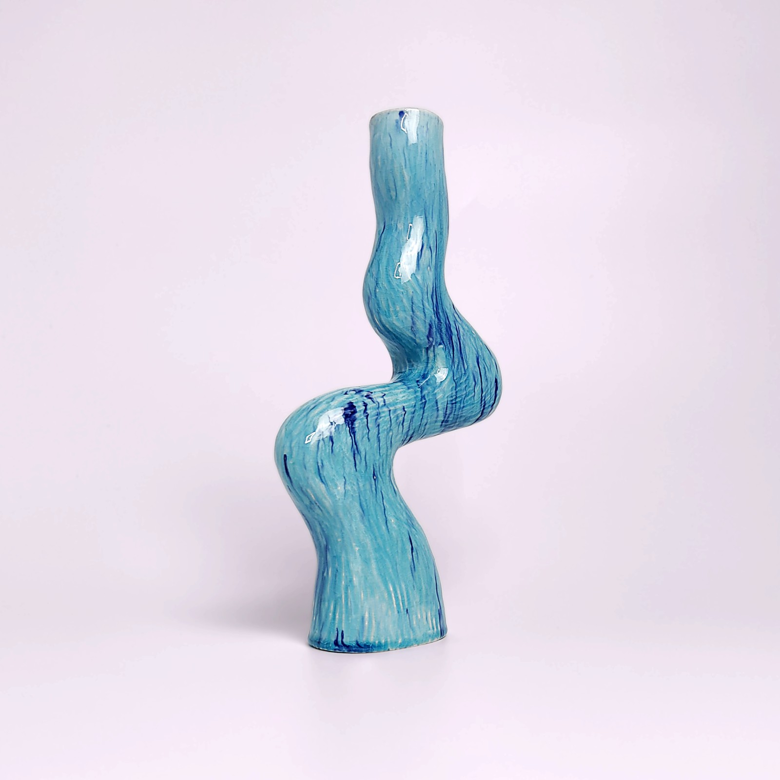 unique handmade ceramic candle holder for a single candle, featuring an organic wavy shape and blue glaze with watercolor-like drips