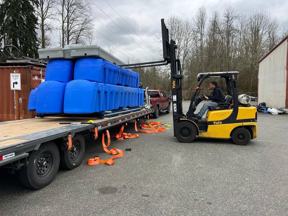 Industrial water tanks loaded on flatbed gooseneck