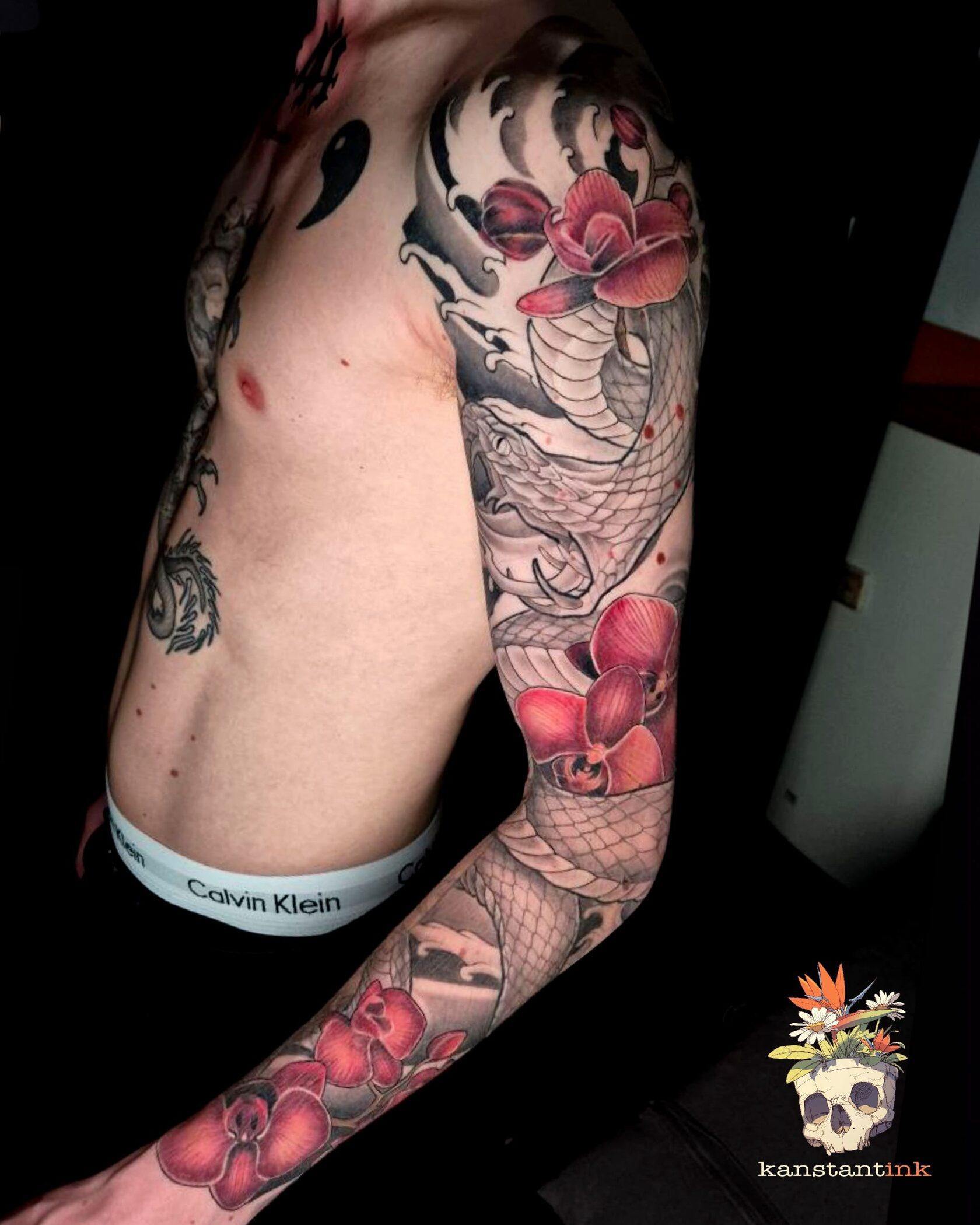 Japanese-inspired arm tattoo with red flowers
