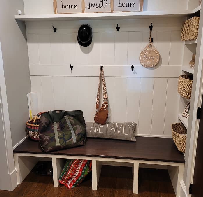 Front view of mudroom shelves and built-in dark stained bench 
