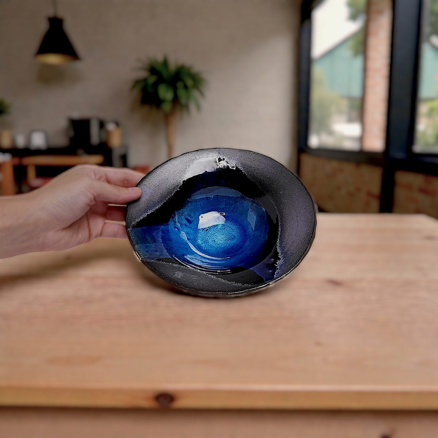 Handmade ceramic decorative plate with matte black rim and deep blue glazed center, modern artistic home decor