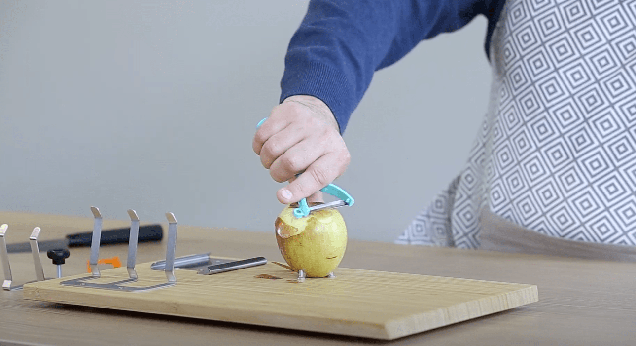 Apfel schälen mit den Spikes auf dem adaptiven Schneidebrett.