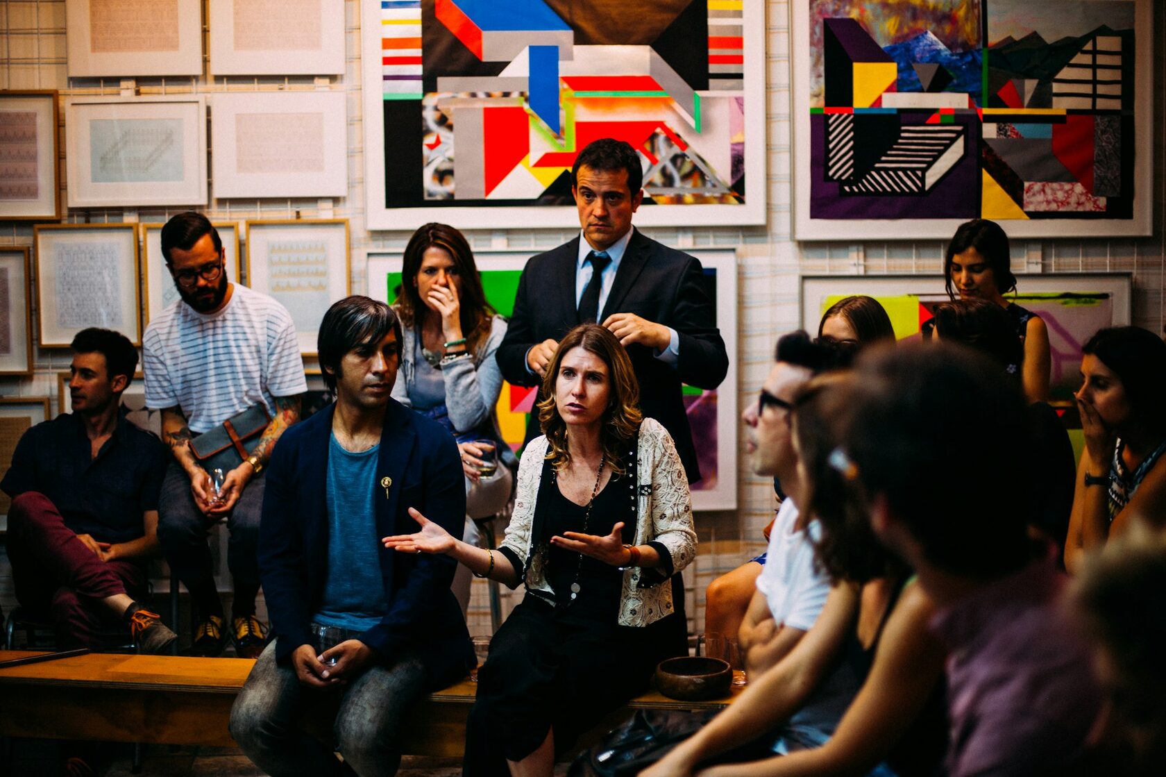 A young participant speaking in a circle of peers during a CWM workshop, mid-thought, with others leaning in to listen.