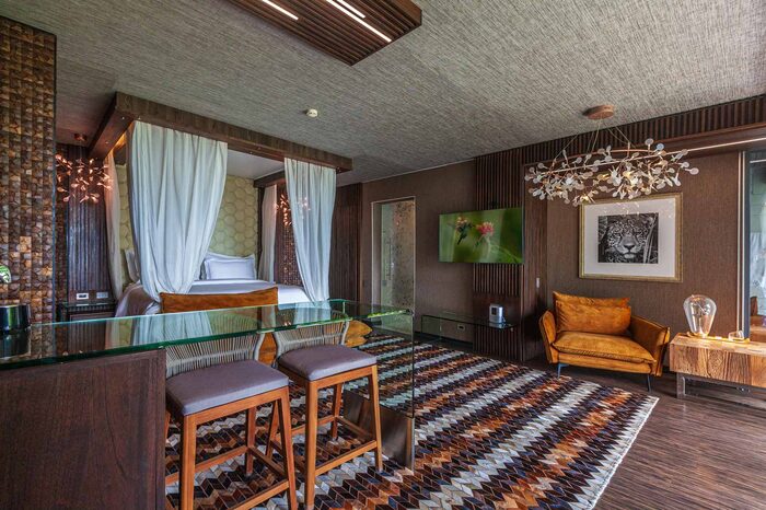 Four-poster bed and treetop balcony in the Deluxe Suite Ocean Club