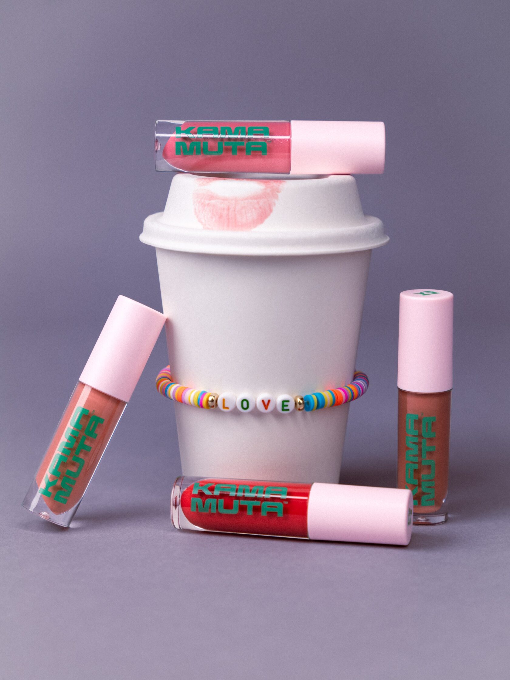 Kama Muta glosses around a coffee cup with LOVE bracelet