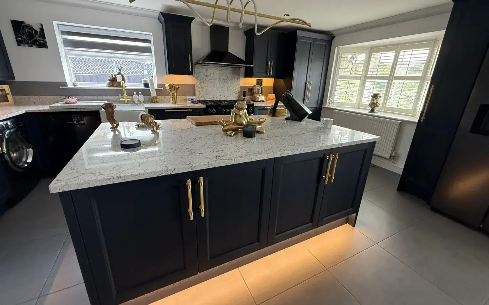 Navy bespoke kitchen island with brass handles and a stone worktop, made by ABJ in Peterborough