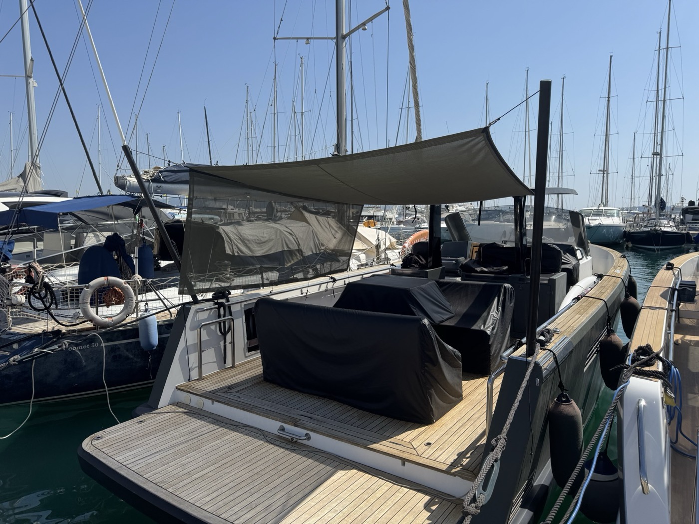 Tendalino di poppa grigio montato su una barca a motore in marina
