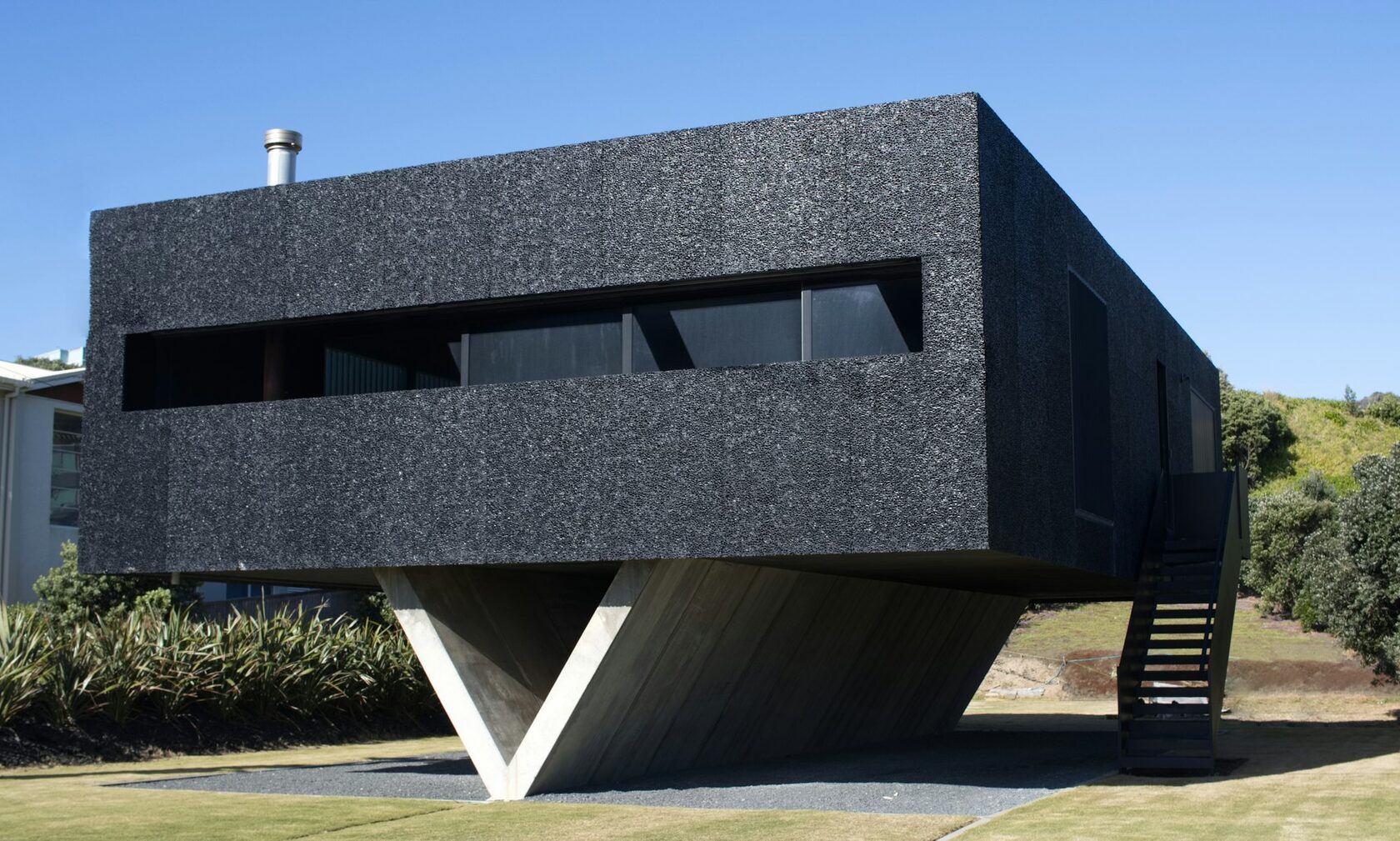 Fachada contemporánea revestida en piedra volcánica