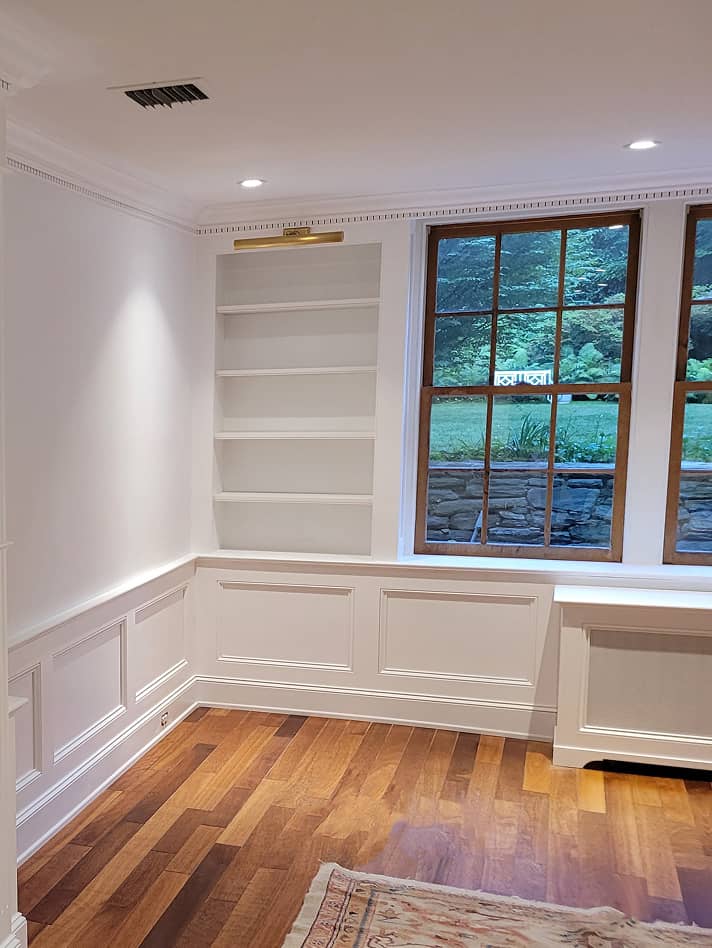 Living room with wainscot paneling and built-in shelves