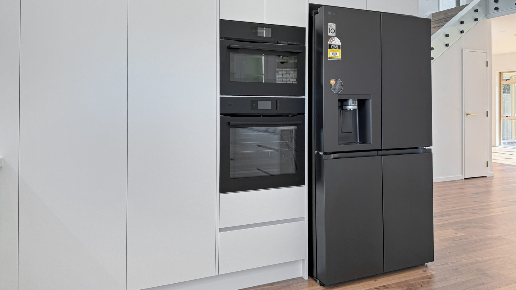 Built-in ovens, full-height cabinetry and black refrigerator in the St Heliers kitchen.