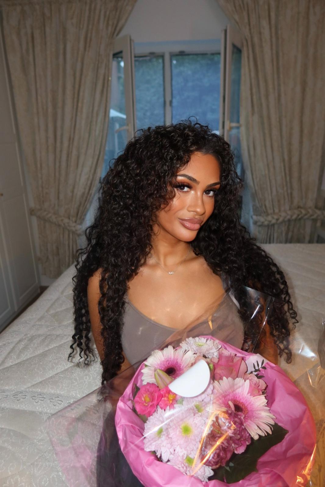 Nour mit einem rosa Blumenstrauß