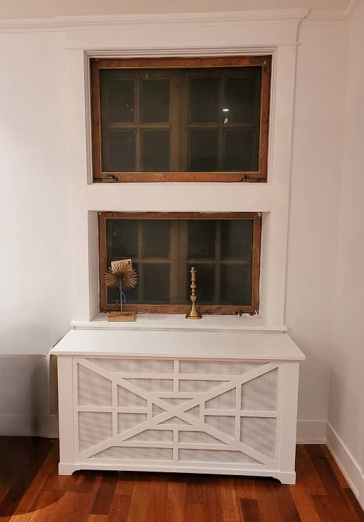 Custom white radiator cover cabinet with wainscot paneling under a window