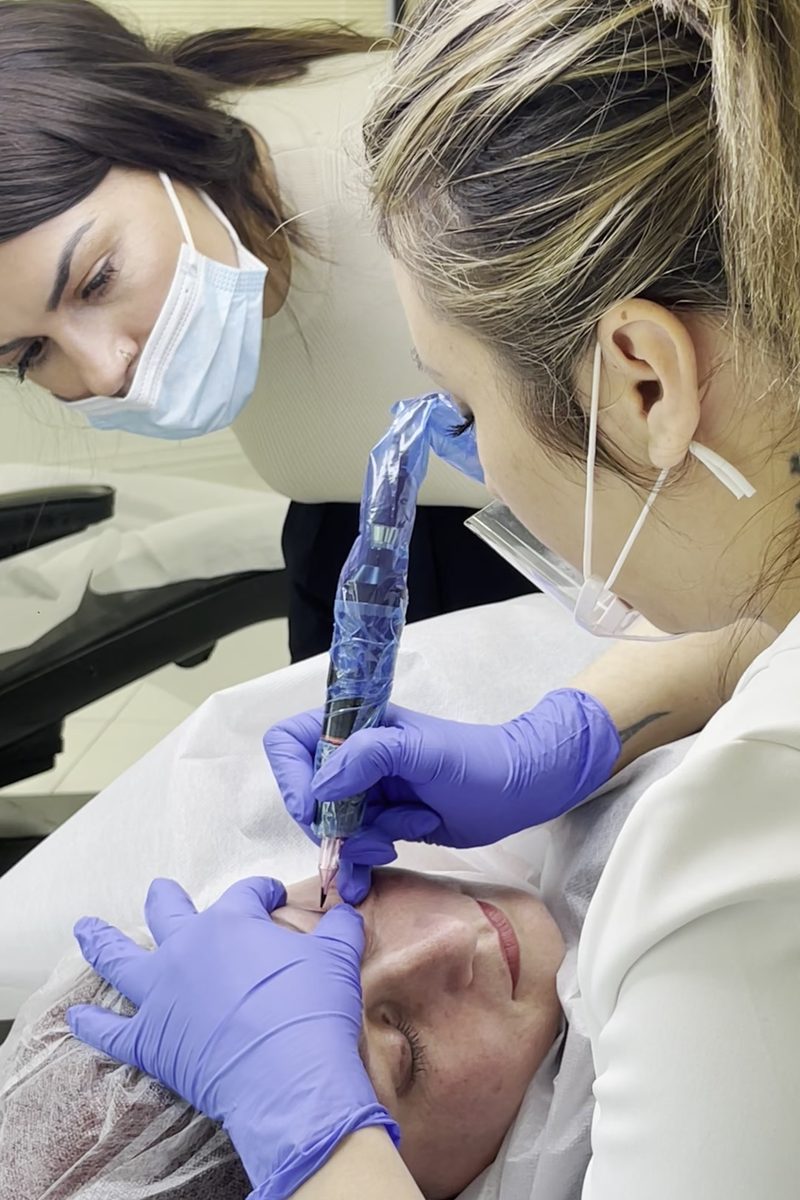 Kristina guiding a Delta student during a procedure on a real client