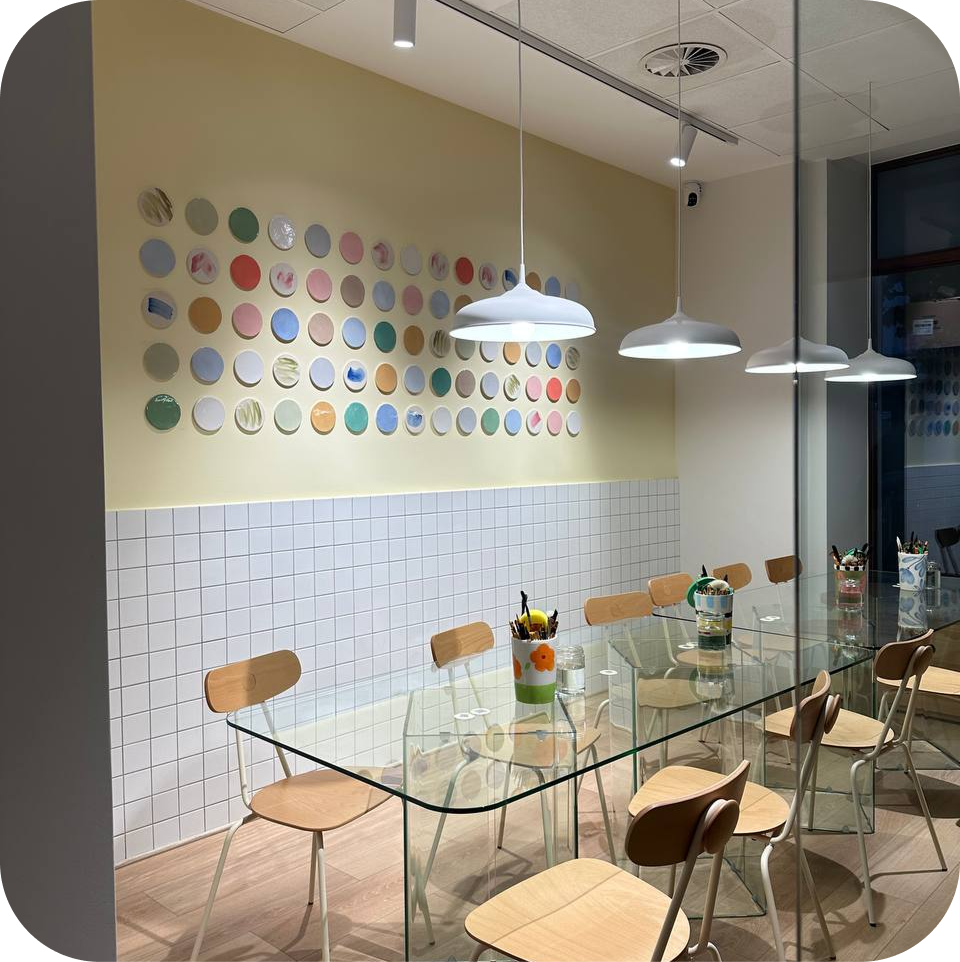 The private Glass Room at Create Cafe Poznań — a glass table and a wall of painted plates