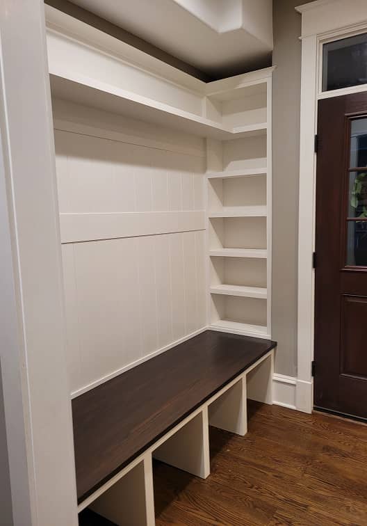 3/4 view of mudroom shelves and built-in dark stained bench 
