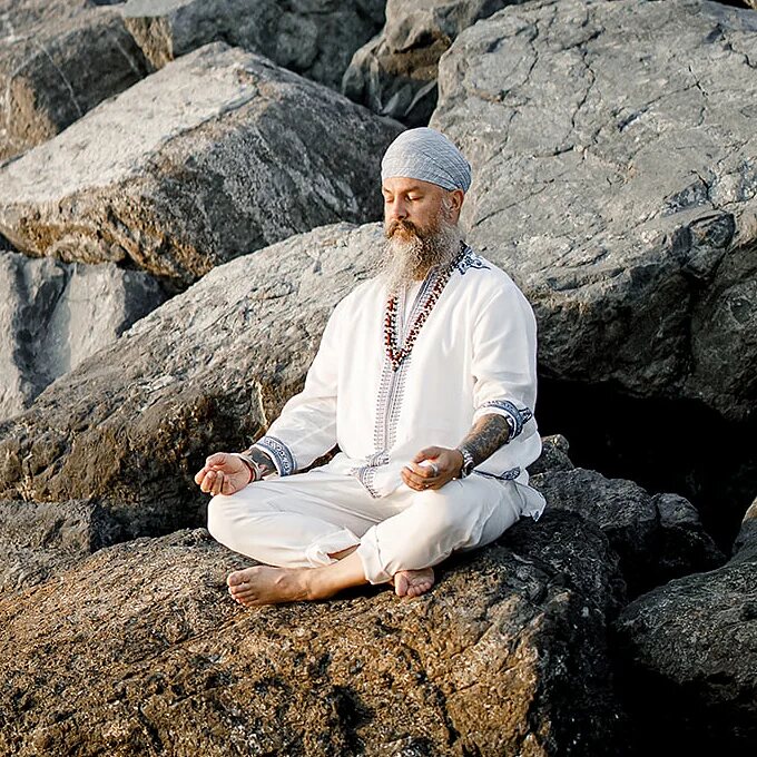Jugat&nbsp;Guru meditating on the rocks by the sea