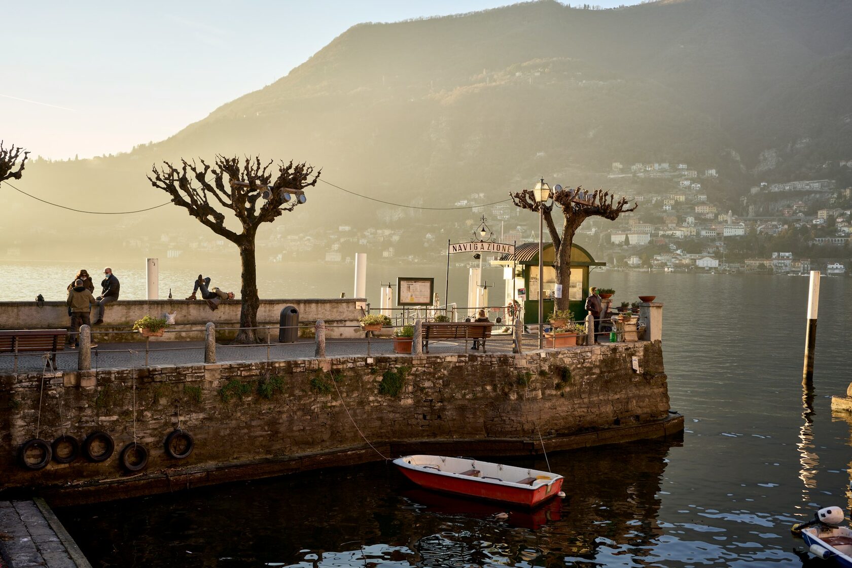 A group raising a toast on a terrace above Lake Como at sunset