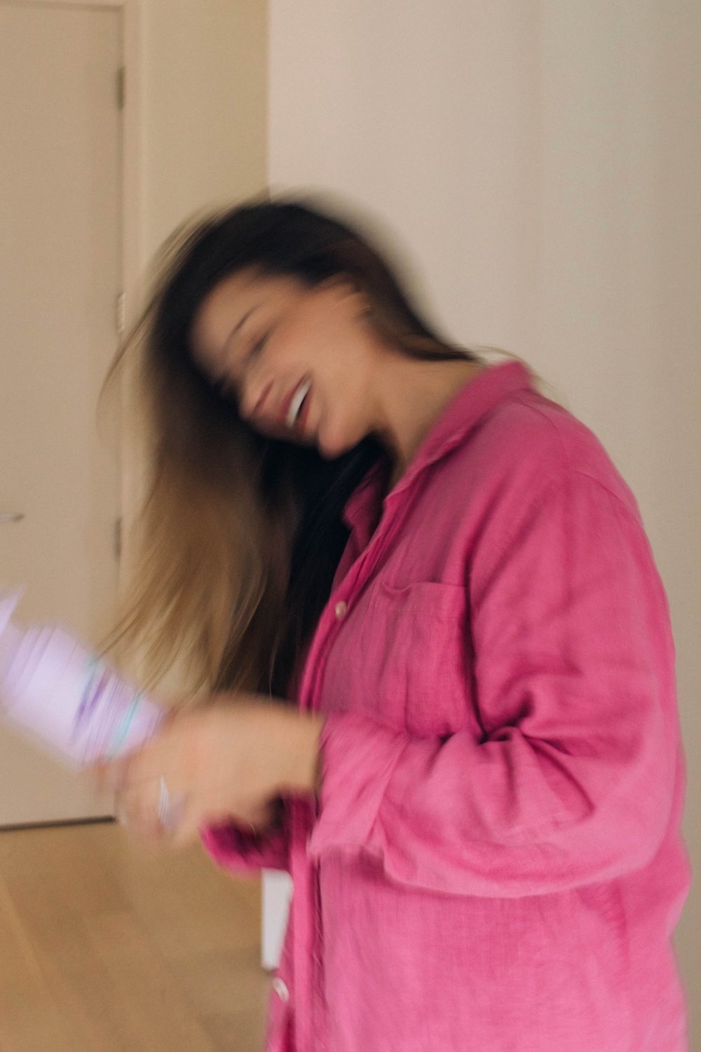 Lo mid-laugh, a blur of pink