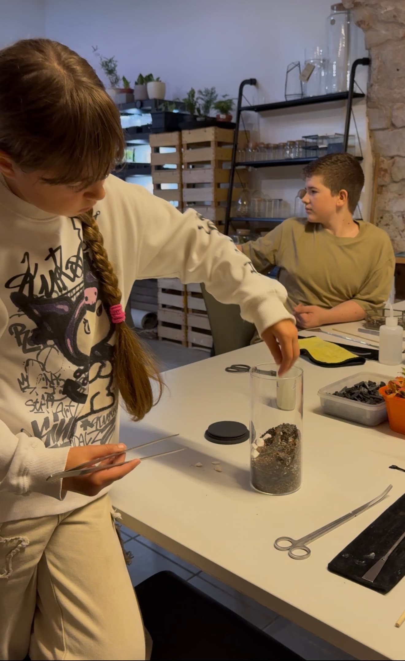 Mädchen legt beim Biotop-Workshop Moos in ein Glas – Kindergeburtstag bei IZSO NaturArt in Lahr