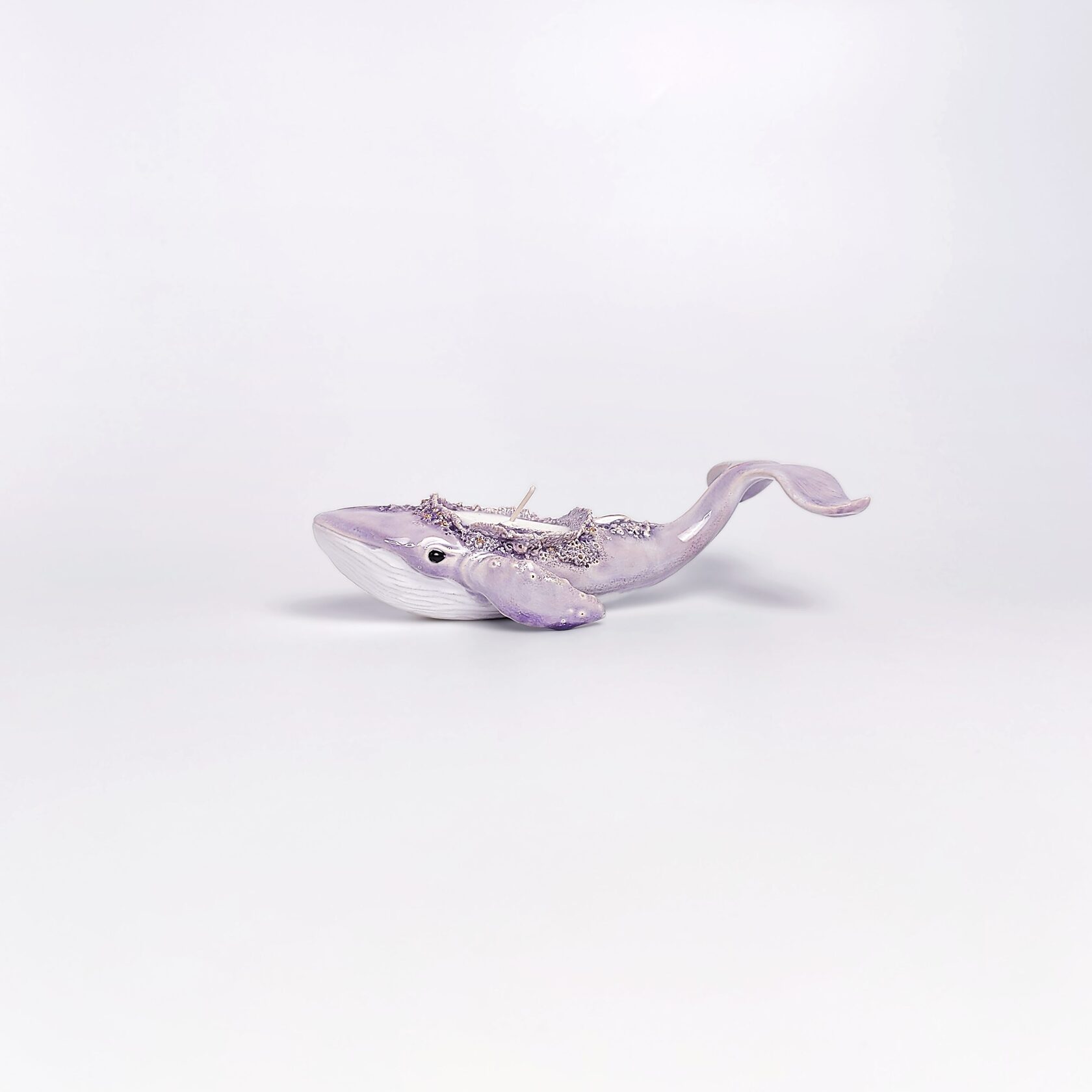 handmade ceramic candle holder shaped like a purple whale with sculptural details