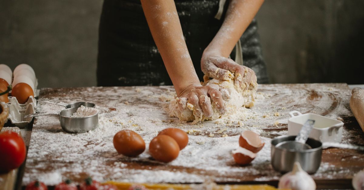 Hands chopping vegetables in a sunny kitchen