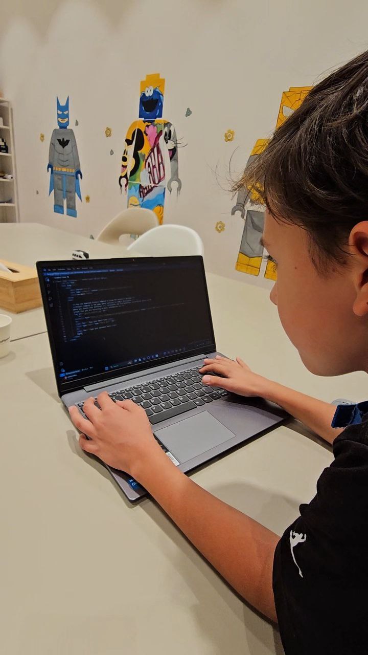 Student learning text-based coding on a laptop