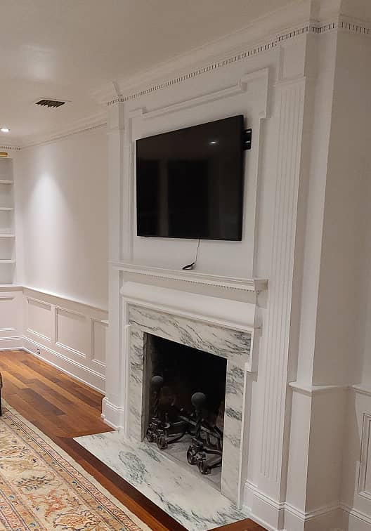 Living room with wainscot paneling and fireplace surround