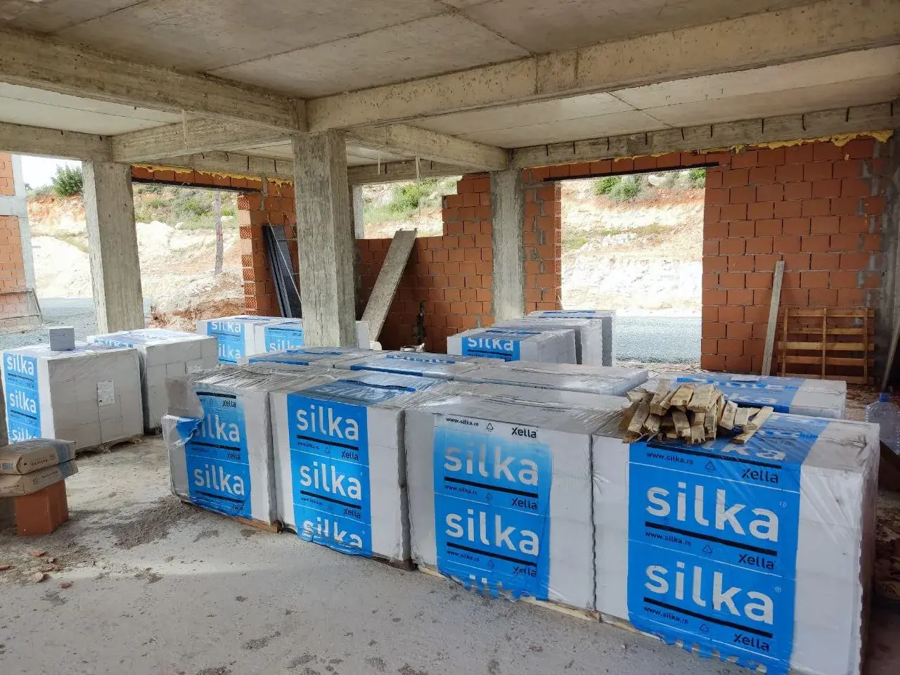 Silka-labelled pallets stored inside the concrete frame. The original photograph is dated 8 April 2024.