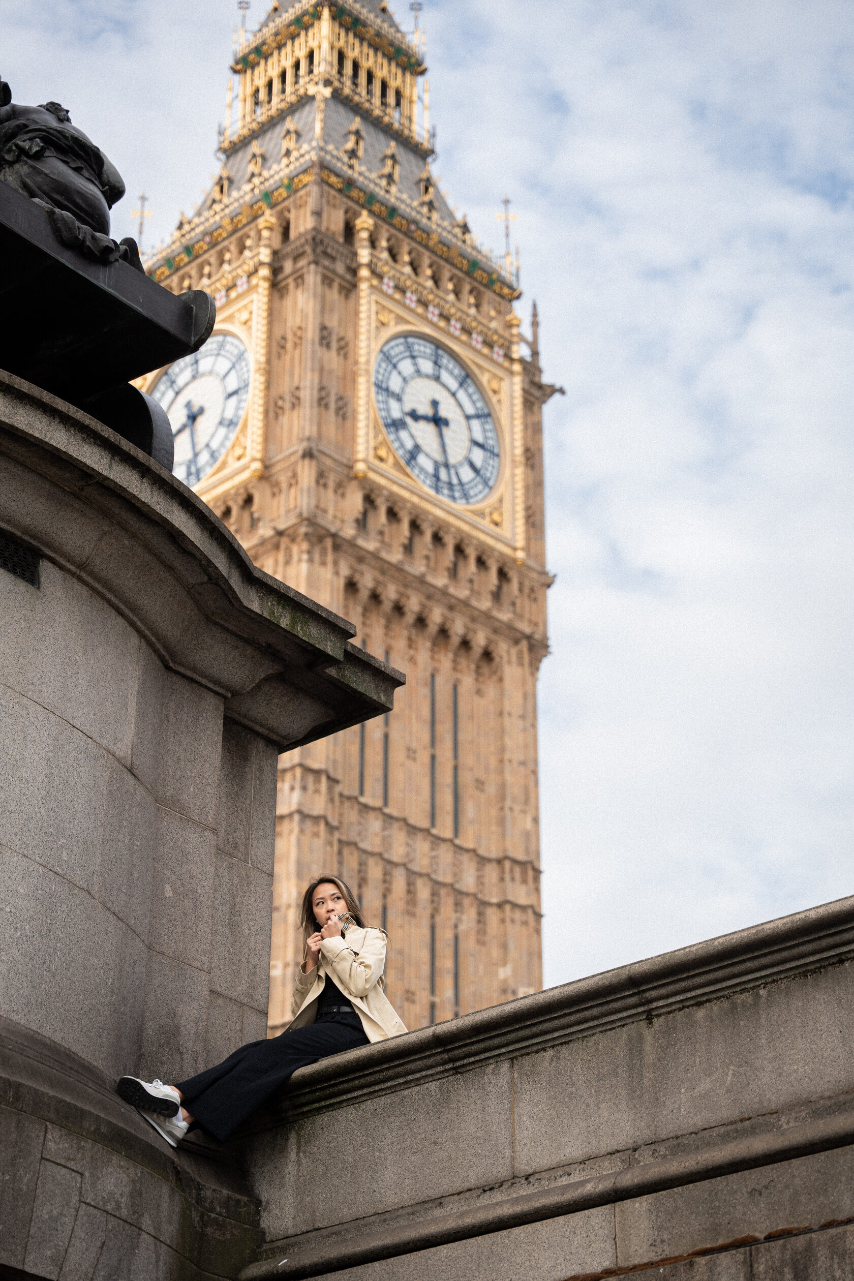 Portrait beside Big Ben with a woman seated on a stone ledge