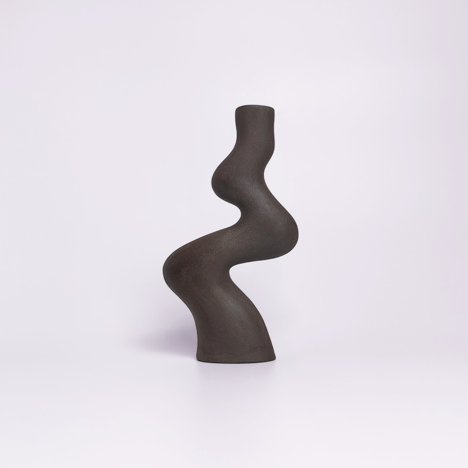 minimalist black handmade ceramic candle holder for a single candle, crafted in an elegant organic curved shape