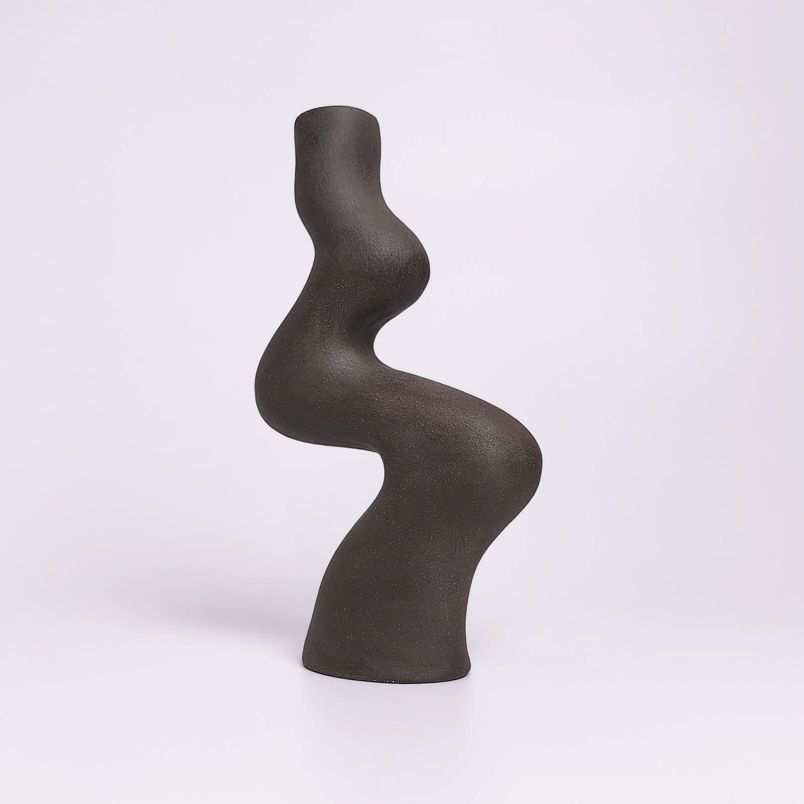 minimalist black handmade ceramic candle holder for a single candle, crafted in an elegant organic curved shape