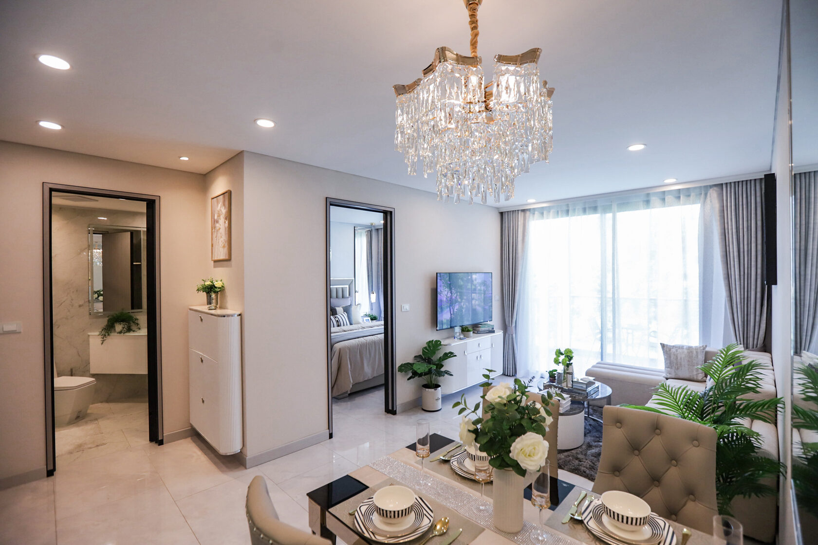 Living and dining room with chandelier in the Copacabana Coral Reef show unit