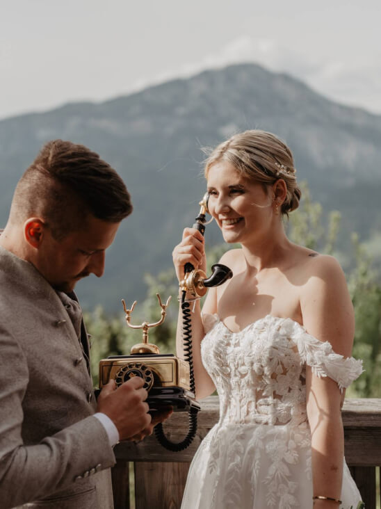 Candid wedding moment with vintage phone on alpine deck — storytelling photography in Schladming, the Austrian mountains