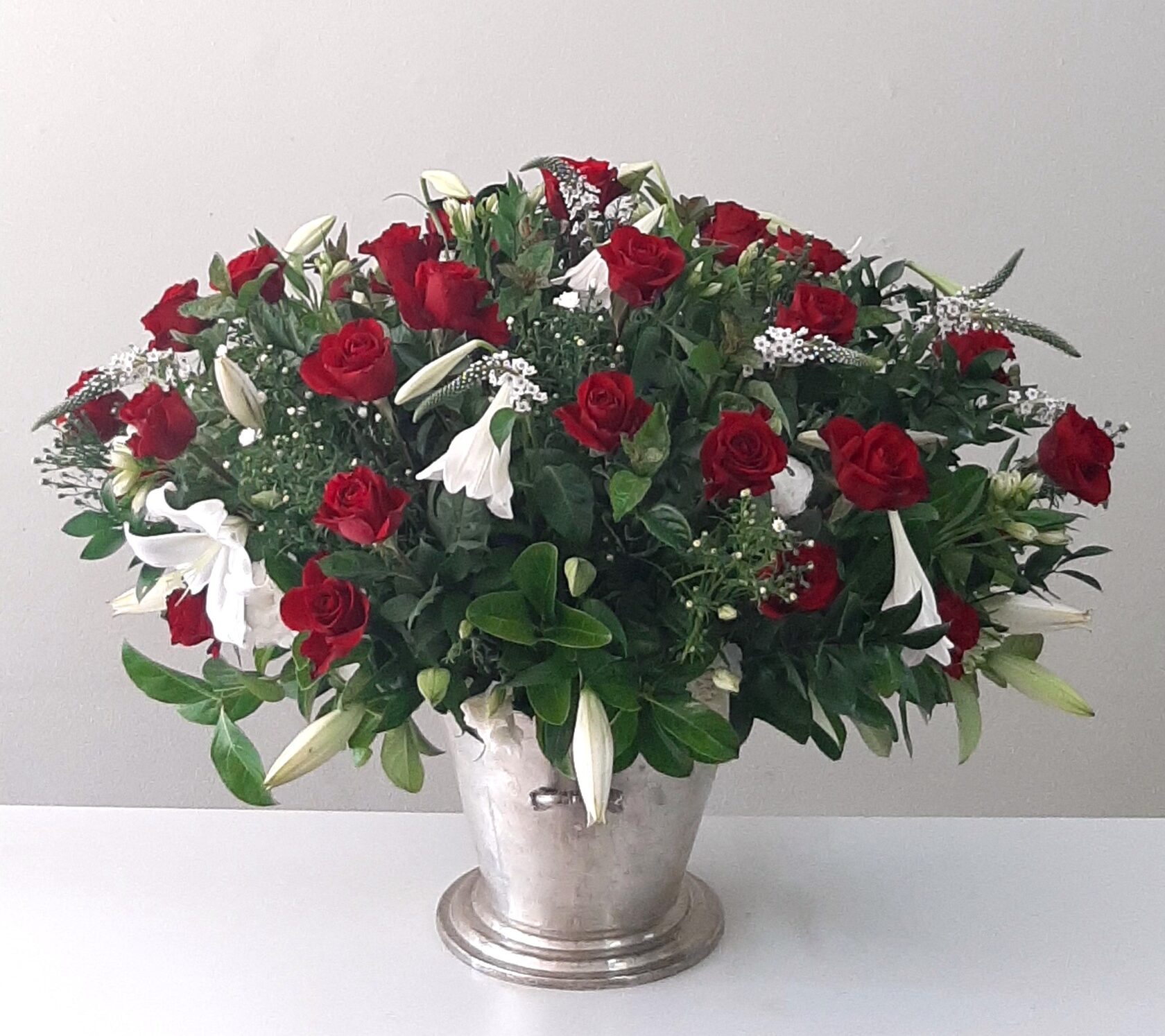 a vibrant floral arrangement with red roses and white lilies