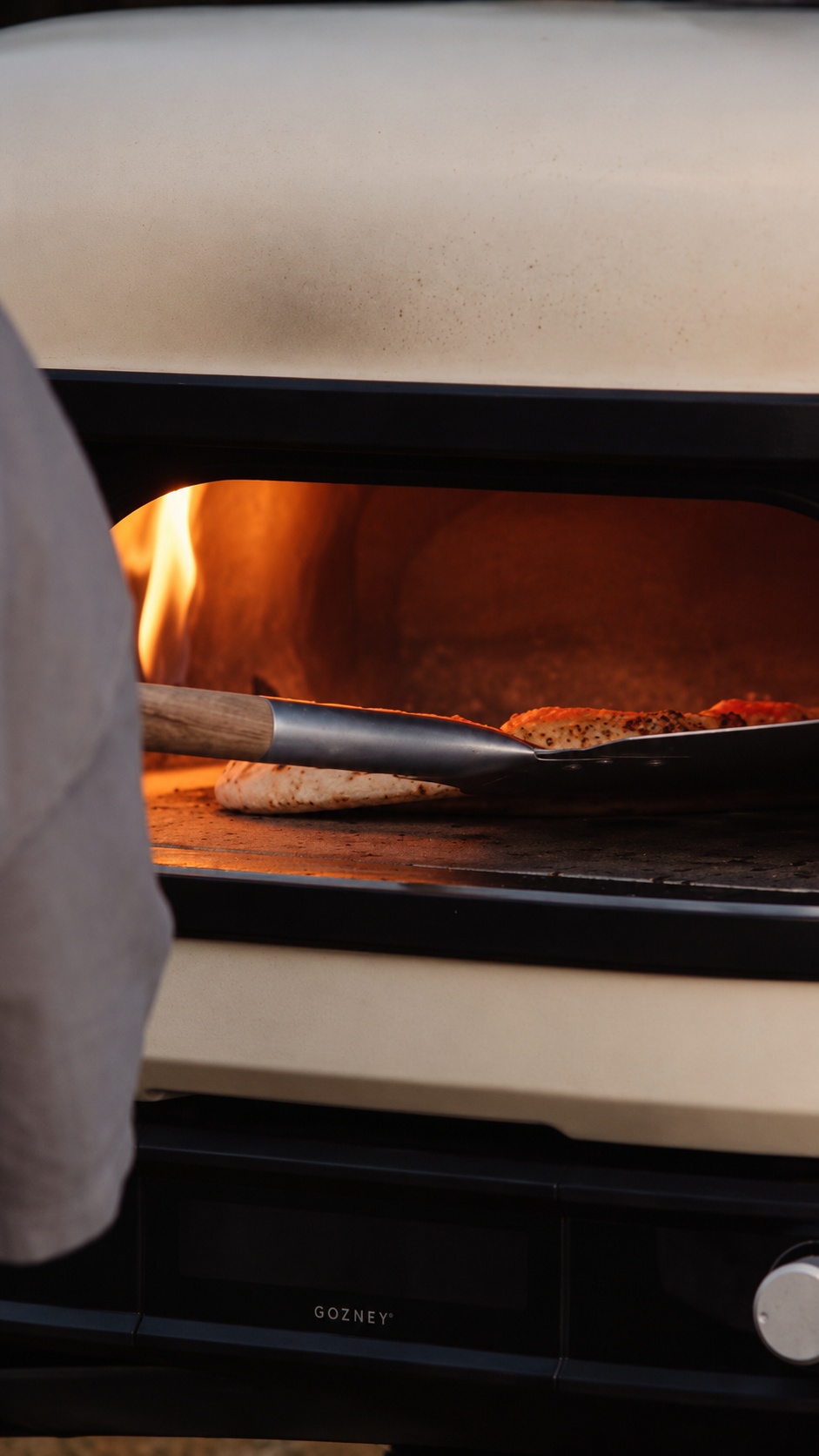 Taking a freshly baked pizza out of the oven