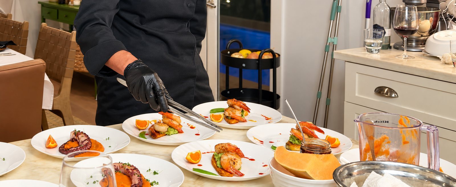 Private chef Marina Staver plating shrimp with sweet potato at an open kitchen island in Boca Raton, near Miami
