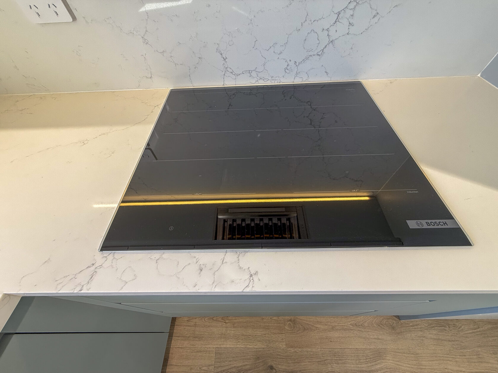 Close view of the kitchen cooktop and its pale work surface