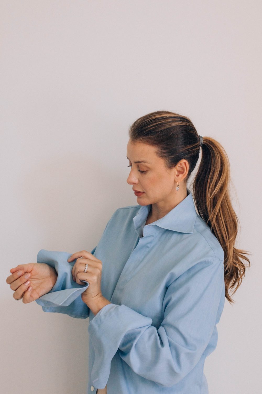 Lo in a blue shirt, rolling up her sleeve