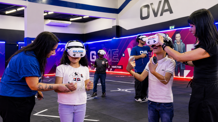 Imagem ilustrativa de crianças usando óculos de realidade virtual com orientação da equipe OVA